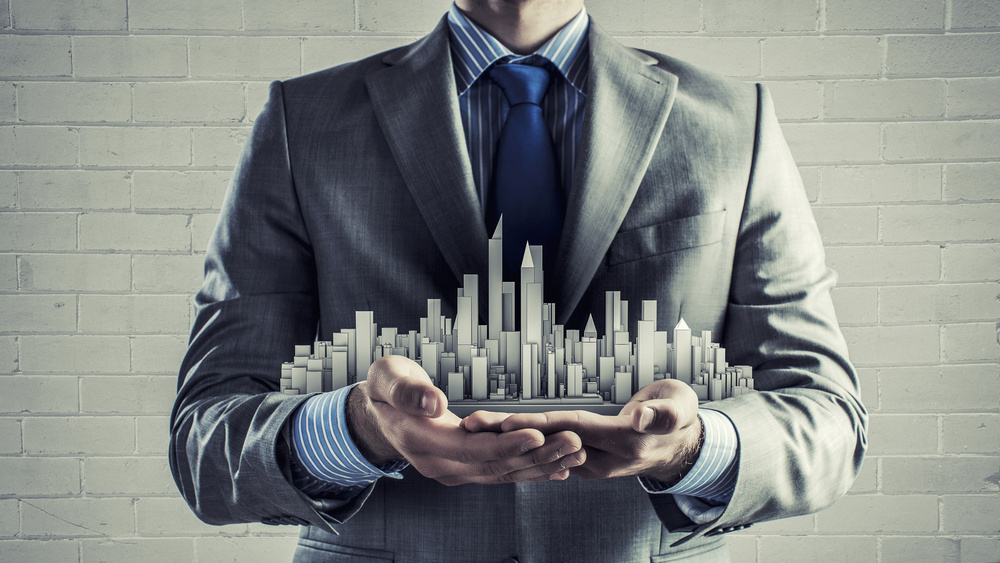 Close up of businessman hand holding construction model